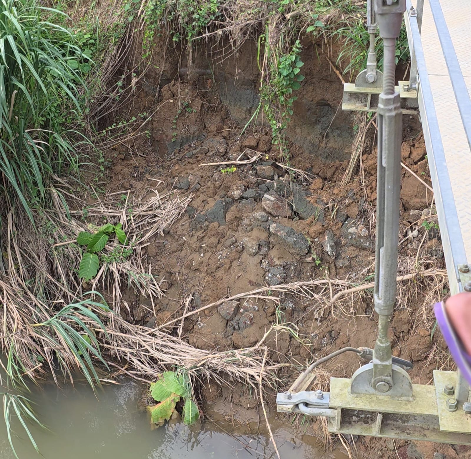 Abrasi yang mengikis tanah sekitar pondasi jembatan gantung